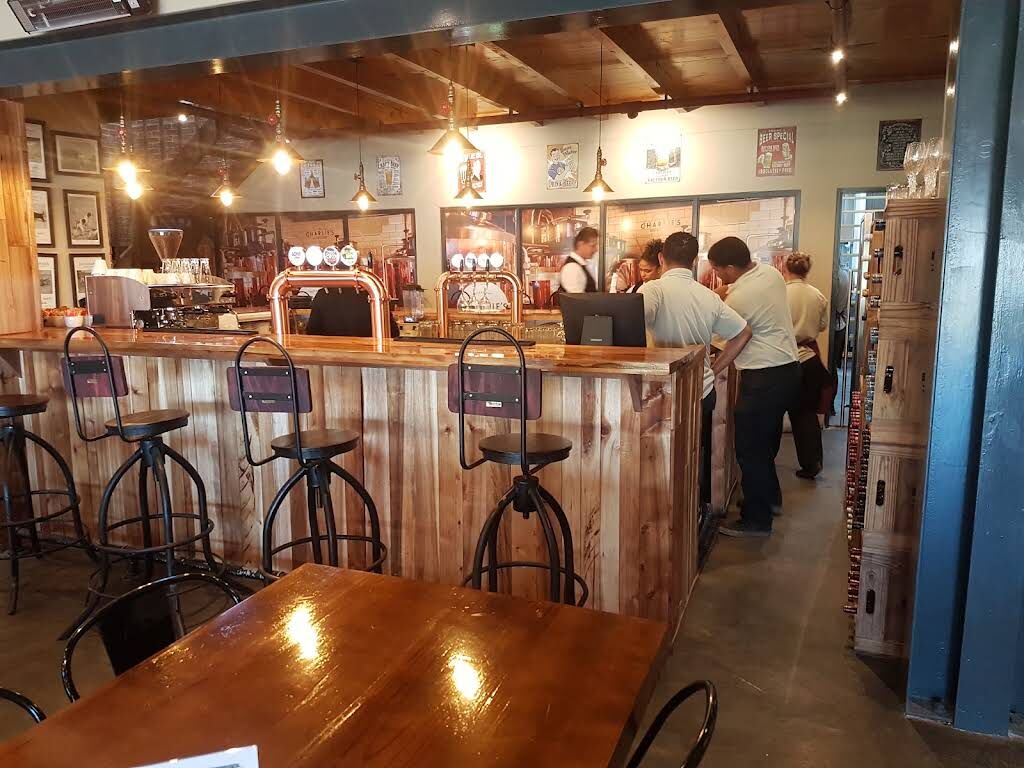 The copper beer taps and wooden bar inside Charlie's Brewhouse