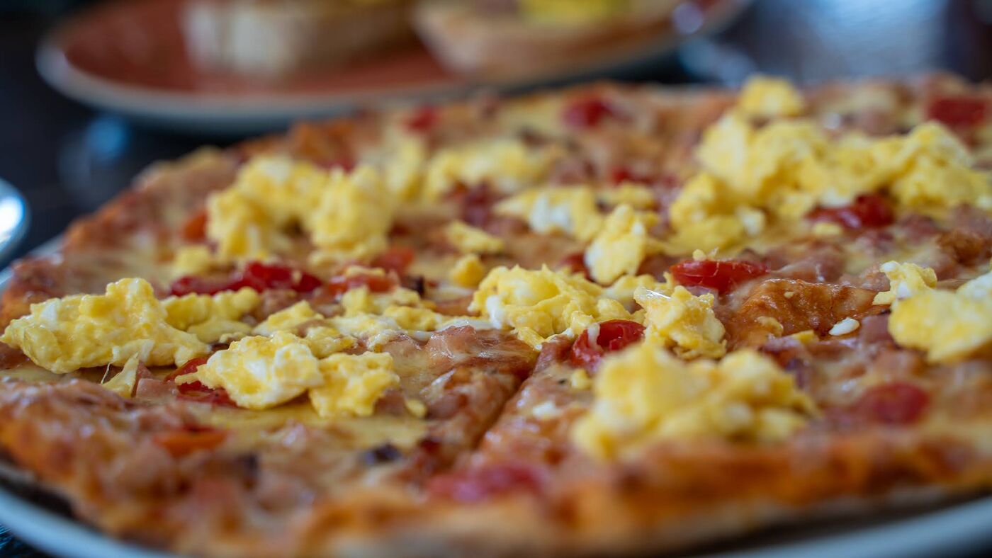 Breakfast pizza with scrambled egg and bacon