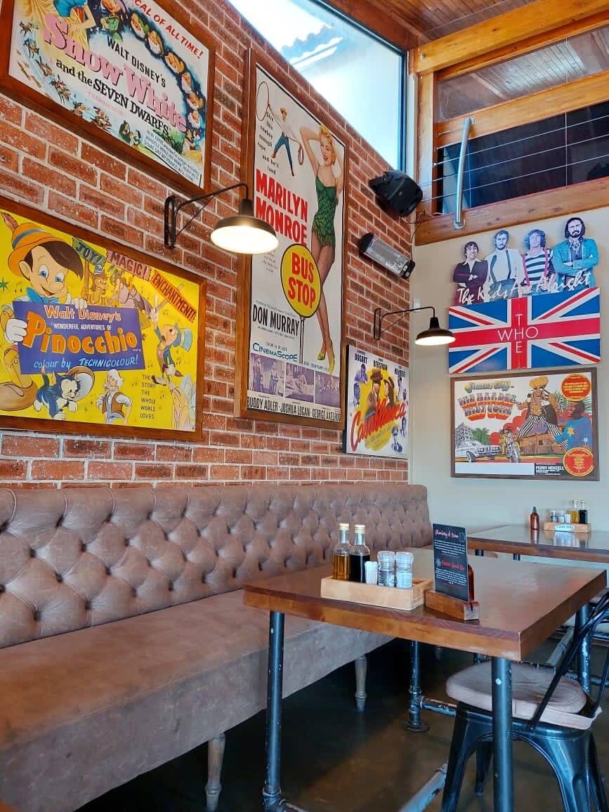 A leather booth under retro signs and a Union Jack on the brick wall